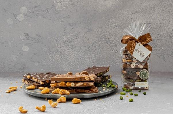 Veganes Schokoladensortiment von Läderach, präsentiert auf einem Teller und in einer klaren Verpackung.